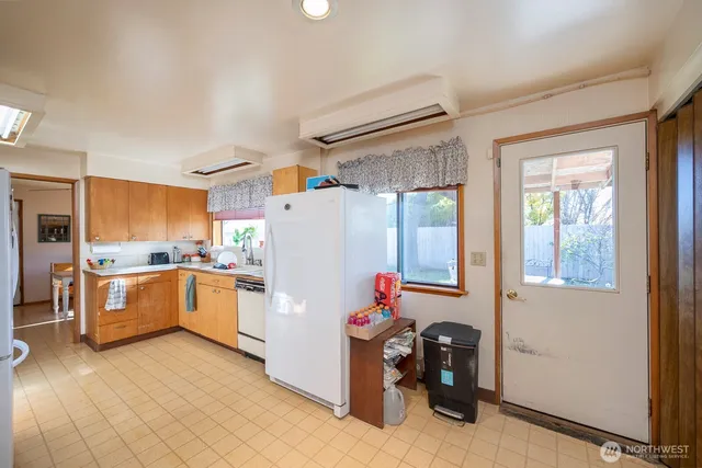 a kitchen with refrigerator and cabinets