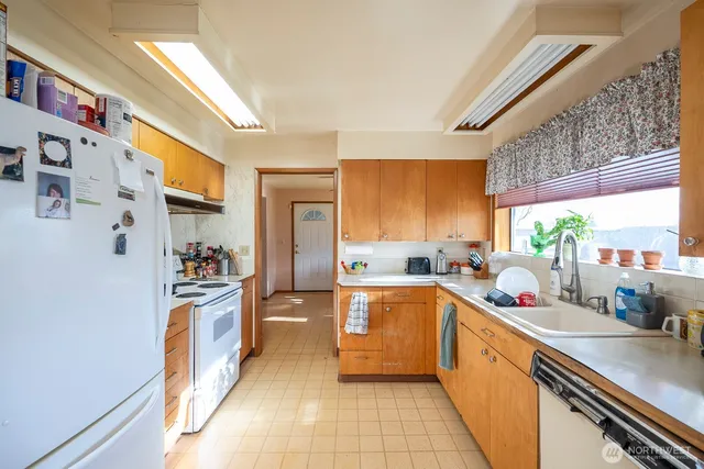 a kitchen with stainless steel appliances a sink window and cabinets