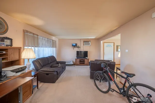 a living room with furniture a flat screen tv and a window