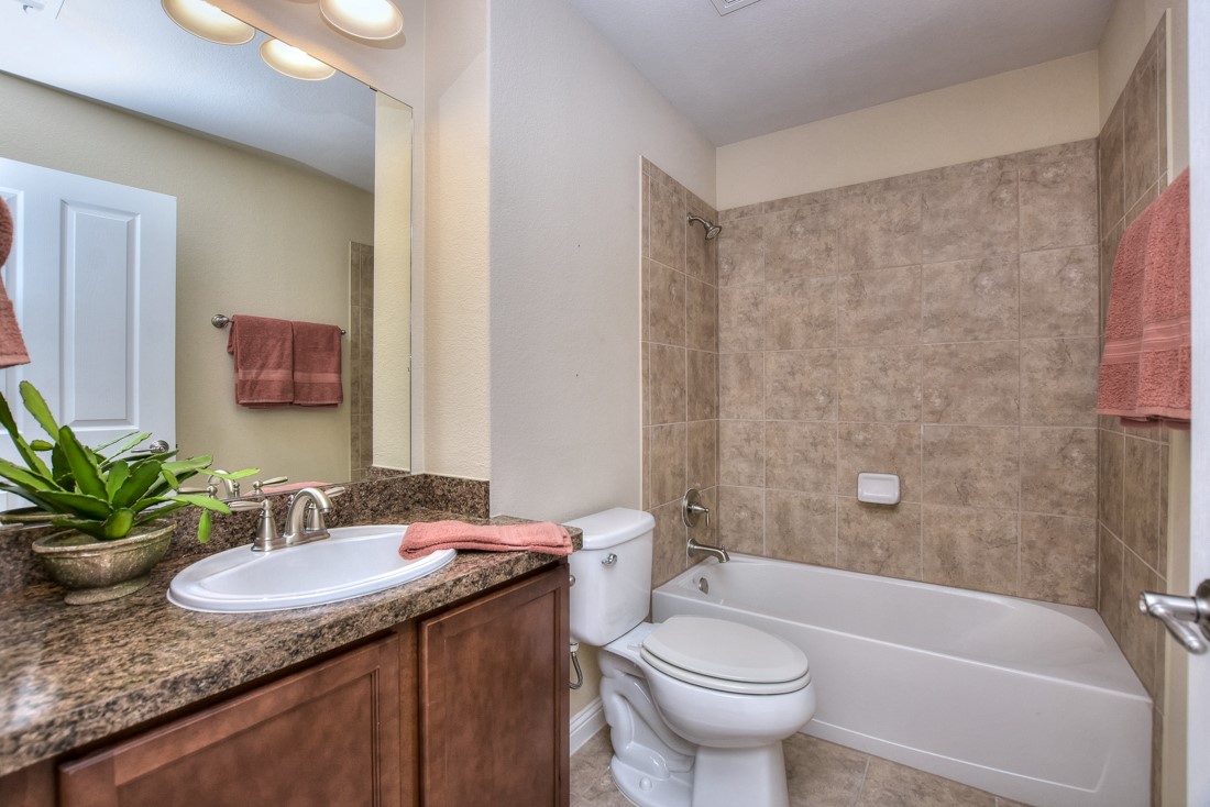 106 Kickapoo Creek Lane Georgetown, TX 78633 - Photo 26 of 33 a bathroom with a granite countertop sink a toilet a mirror a vanity and shower