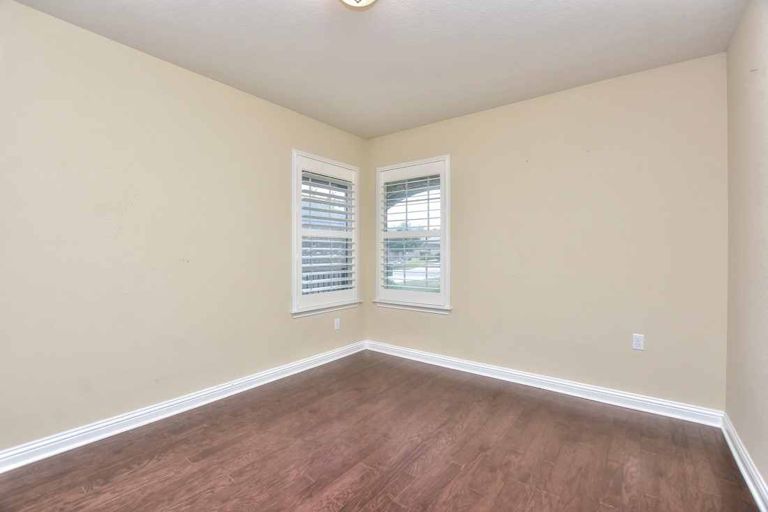 106 Kickapoo Creek Lane Georgetown, TX 78633 - Photo 7 of 33 an empty room with wooden floor and windows