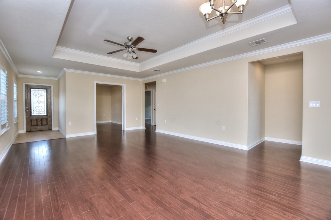 106 Kickapoo Creek Lane Georgetown, TX 78633 - Photo 8 of 33 a view of an empty room with wooden floor and a ceiling fan