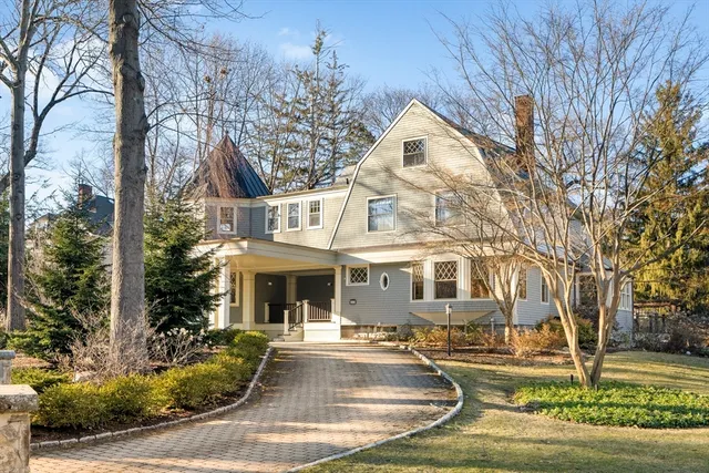a front view of a house with garden and trees