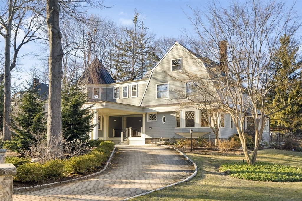 a front view of a house with garden and trees