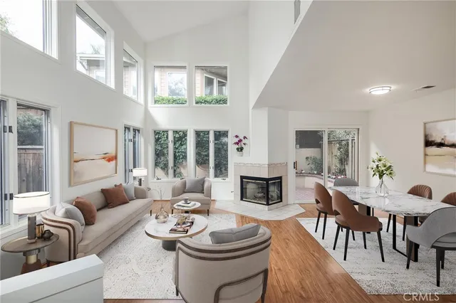 a living room with furniture a fireplace and a dining table with wooden floor