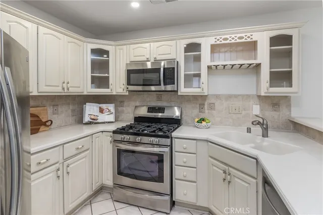 a kitchen with stainless steel appliances granite countertop white cabinets sink and stove
