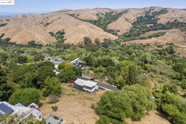 an aerial view of a house with a mountain