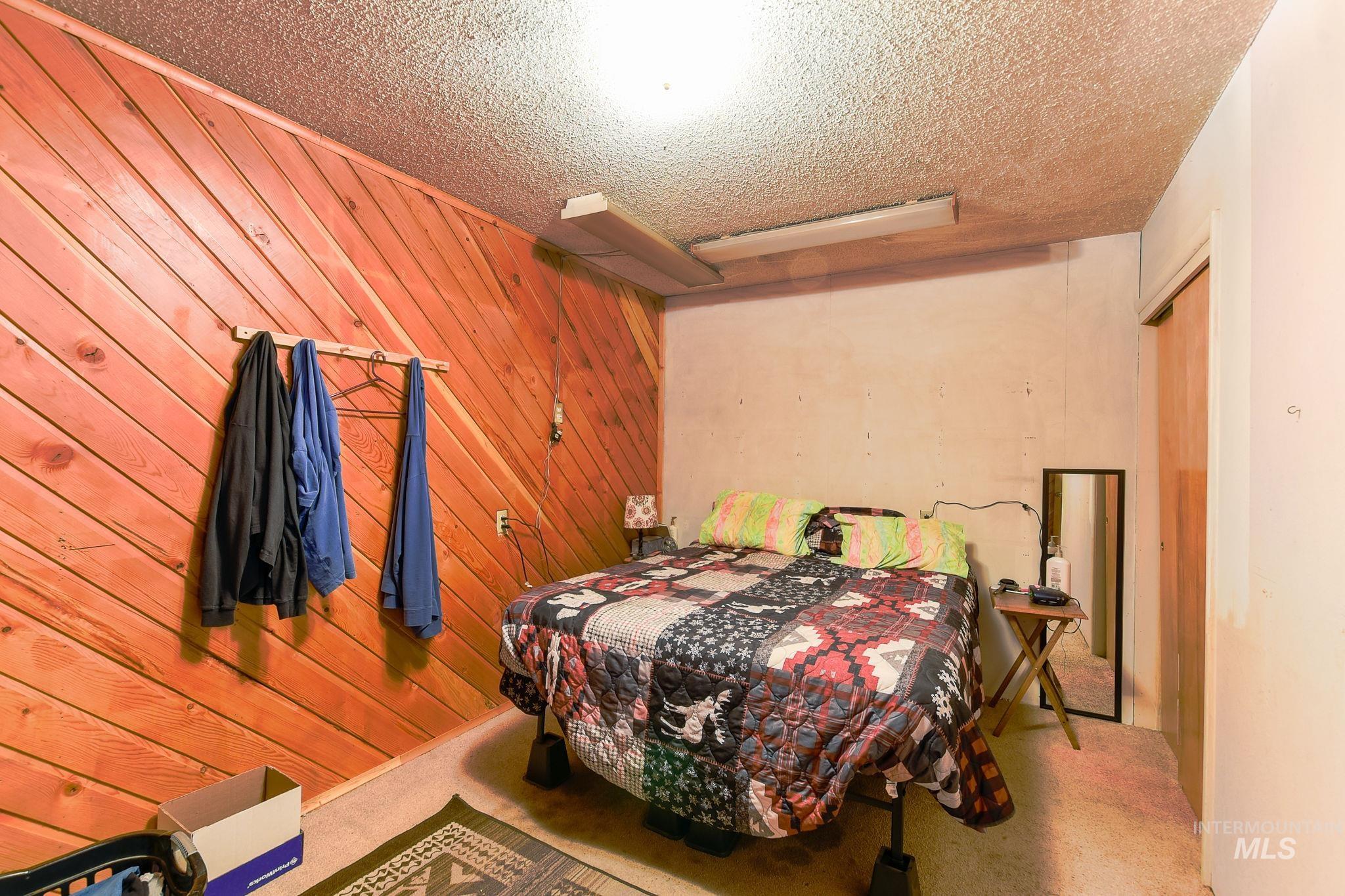 243 North Fir Street Genesee, ID 83832 - Photo 11 of 50 Bedroom with wooden walls and a textured ceiling