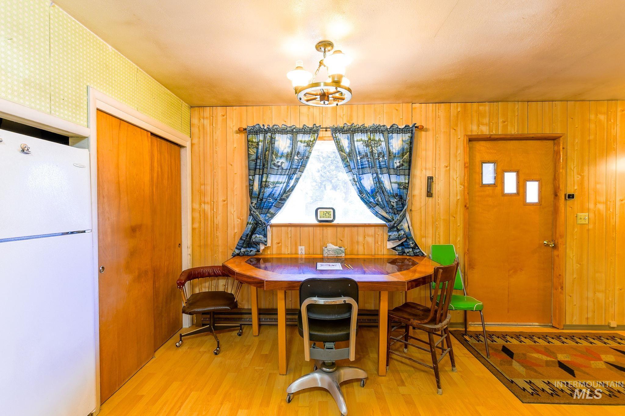 243 North Fir Street Genesee, ID 83832 - Photo 14 of 50 Dining space featuring wood finished floors, a chandelier, and wood walls