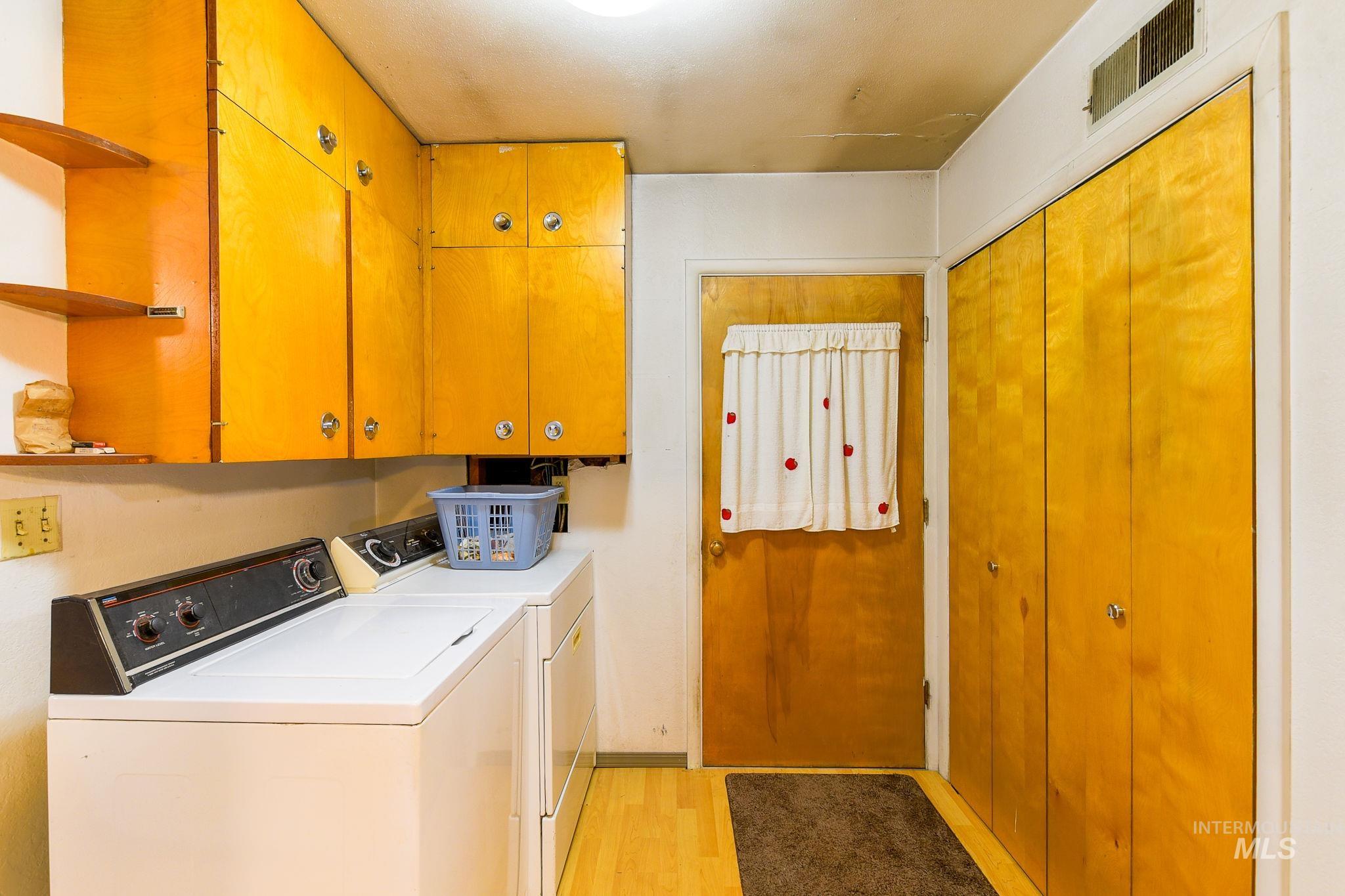 243 North Fir Street Genesee, ID 83832 - Photo 21 of 50 Laundry area with light wood-style flooring, washer and clothes dryer, and cabinet space