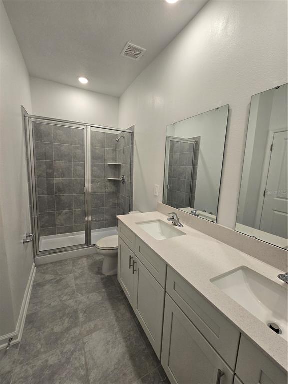 1767 Foreman Road Eagle Lake, FL 33839 - Photo 10 of 30 a bathroom with a double vanity sink toilet and shower