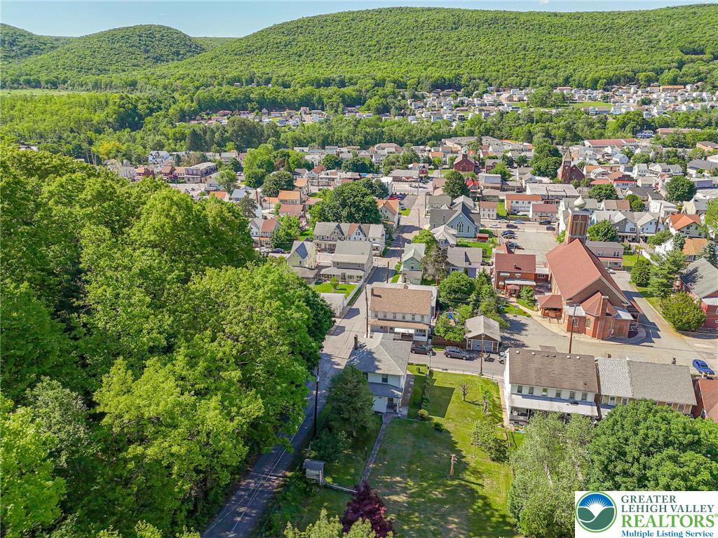 159 West Ridge Street Nesquehoning, PA 18240 - Photo 48 of 55 An aerial panorama reveals a vibrant community nestled among verdant hillsides, offering peaceful suburban living.