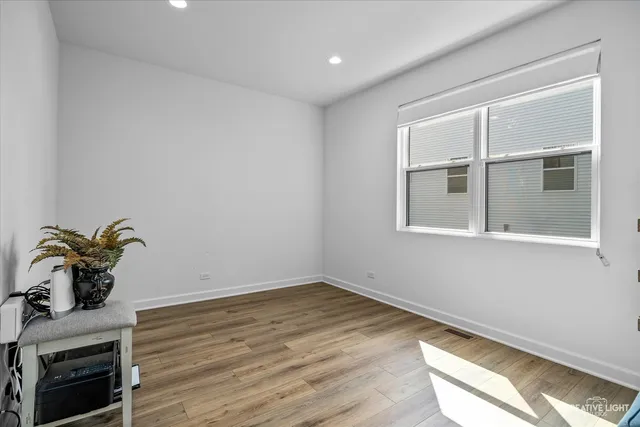 a room with a potted plant with the floor to ceiling window and wooden floor