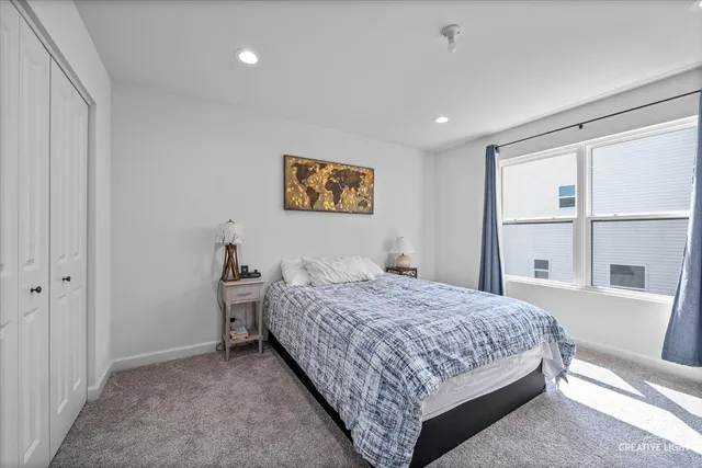 a bedroom with a bed and a large window