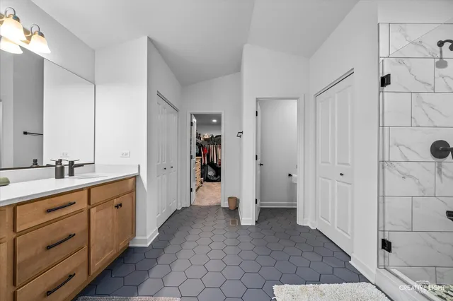 a spacious bathroom with a double vanity sink a mirror and a shower