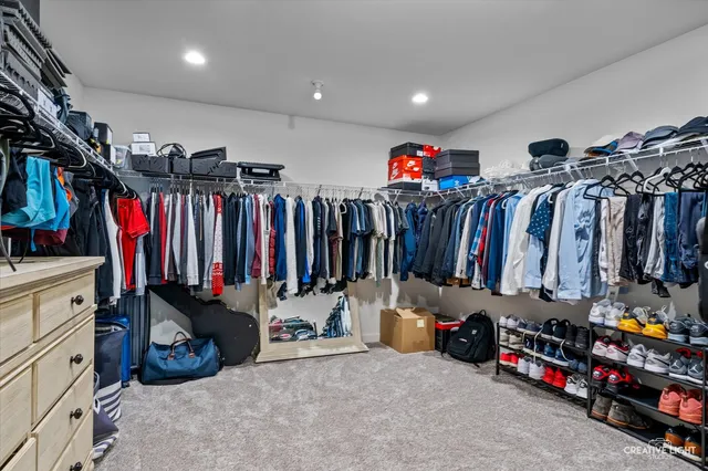 a view of walk in closet with clothes and shoes