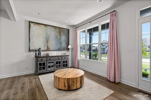 a living room with a large window and wooden floor