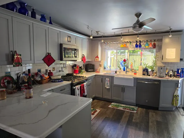 a kitchen with stainless steel appliances granite countertop a sink a stove and a refrigerator