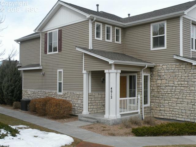 4012 Diamond Ridge View Colorado Springs, CO 80918 - Photo 2 of 15 Front of townhome, with large grass area in front, many windows