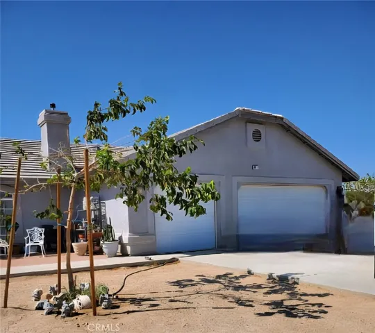 a front view of a house with palm trees