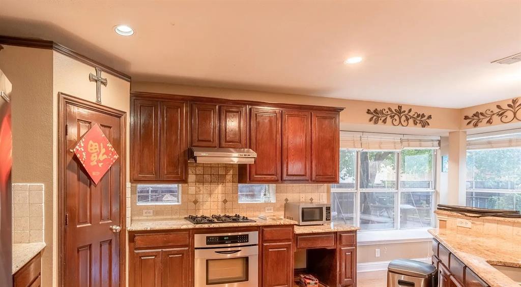 3829 Walnut Ridge Lane Plano, TX 75074 - Photo 4 of 18 a kitchen with stainless steel appliances a stove and cabinets