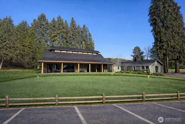 a view of a big house with a big yard and large trees