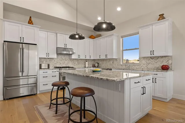a kitchen with cabinets stainless steel appliances and a center island