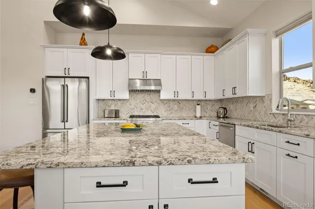 a kitchen with stainless steel appliances granite countertop a sink a stove and cabinets