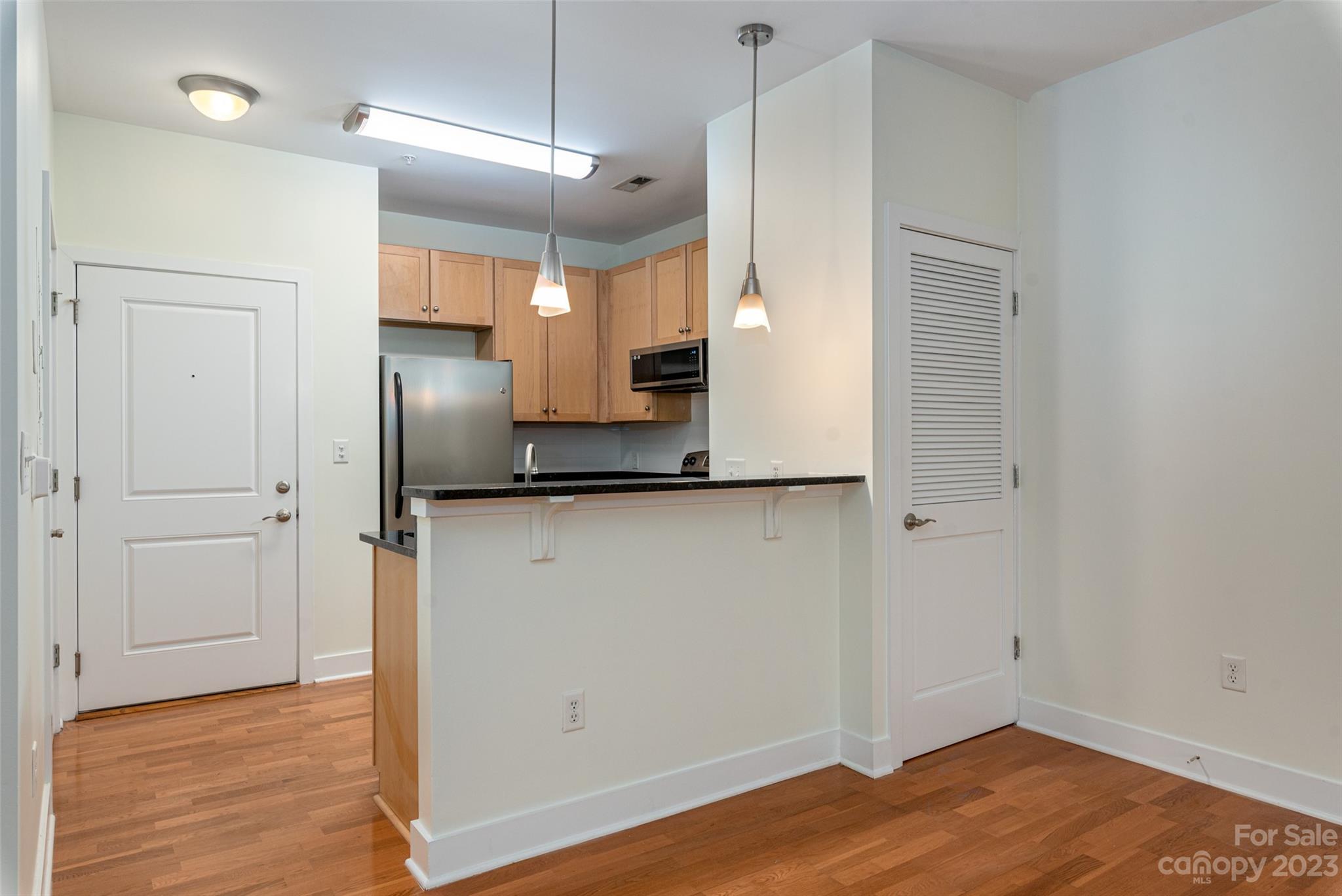 630 Calvert Street, Unit 307 Charlotte, NC 28208 - Photo 13 of 27 a view of a kitchen with a refrigerator and a stove top oven