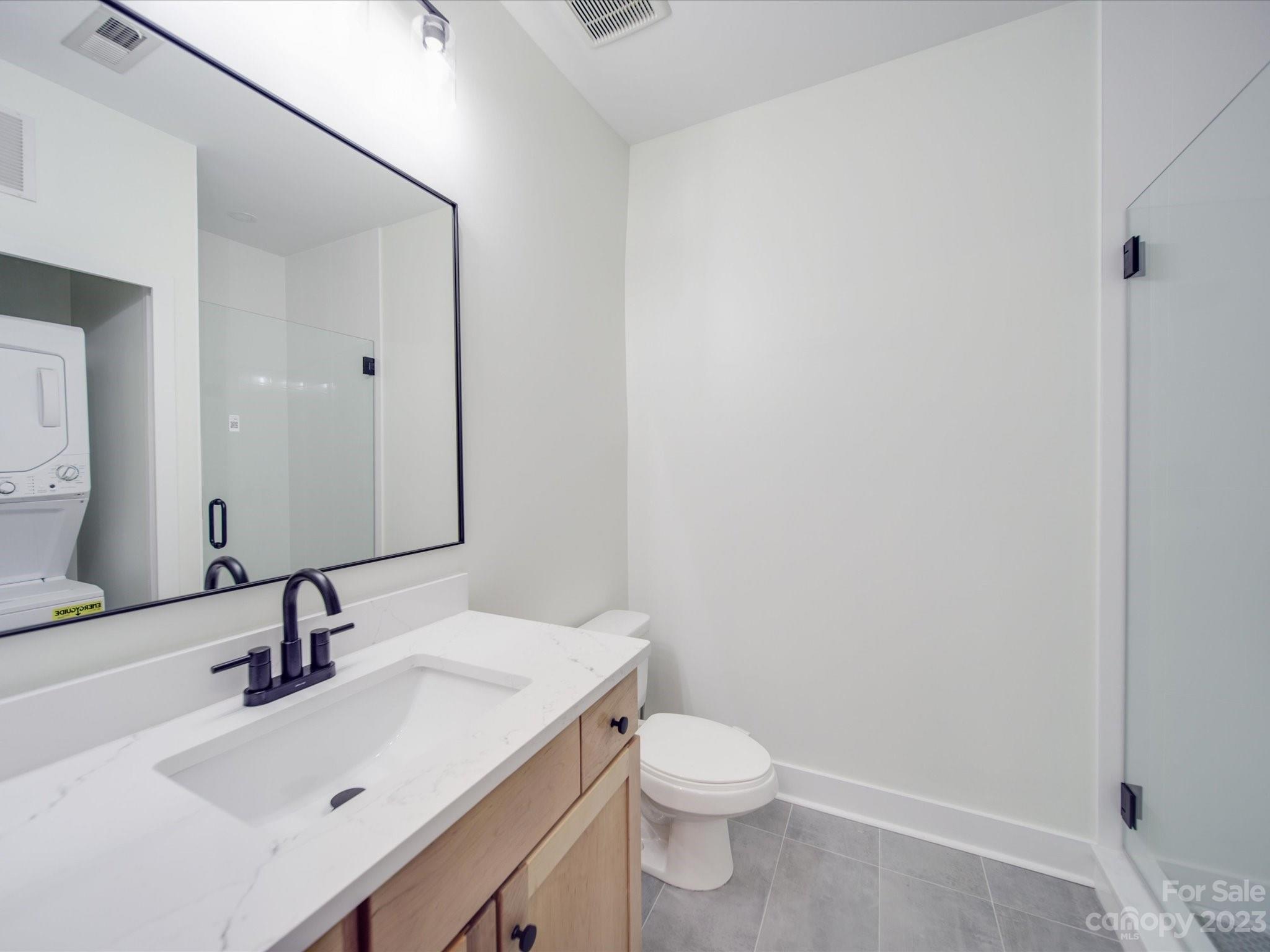 630 Calvert Street, Unit 307 Charlotte, NC 28208 - Photo 17 of 27 a bathroom with a sink a toilet and a mirror