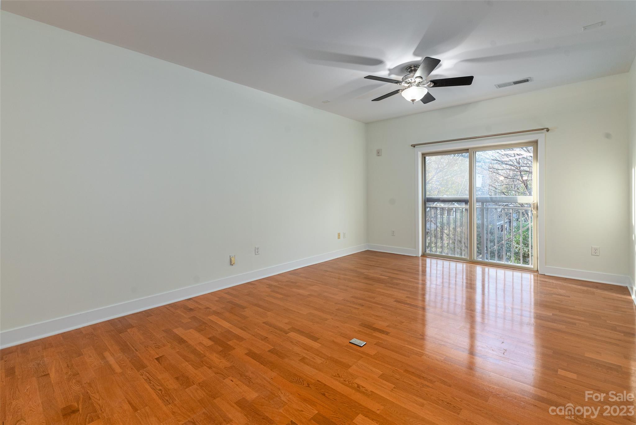 630 Calvert Street, Unit 307 Charlotte, NC 28208 - Photo 3 of 27 a view of an empty room with wooden floor and a window