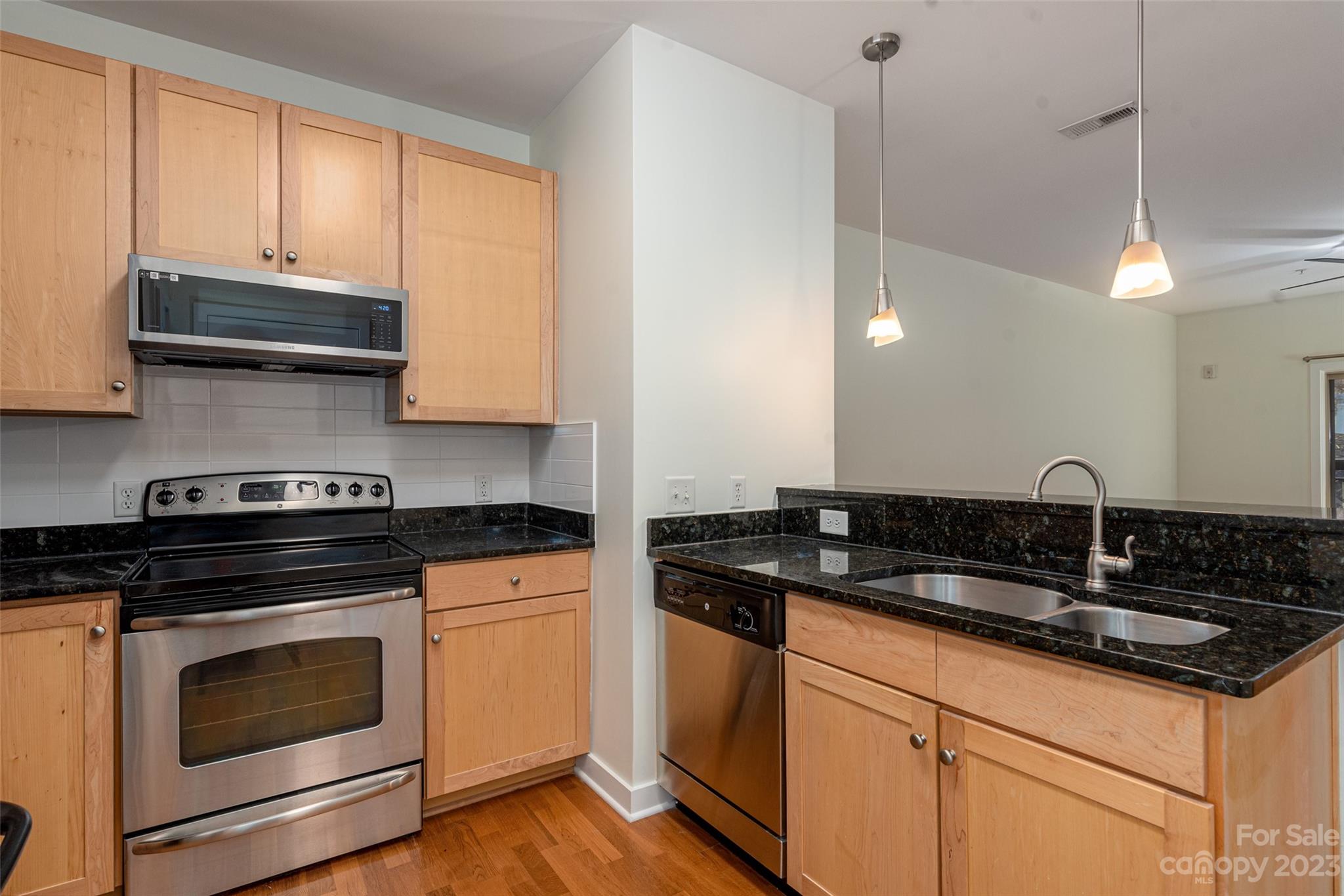630 Calvert Street, Unit 307 Charlotte, NC 28208 - Photo 6 of 27 a kitchen with granite countertop a sink a stove and cabinets