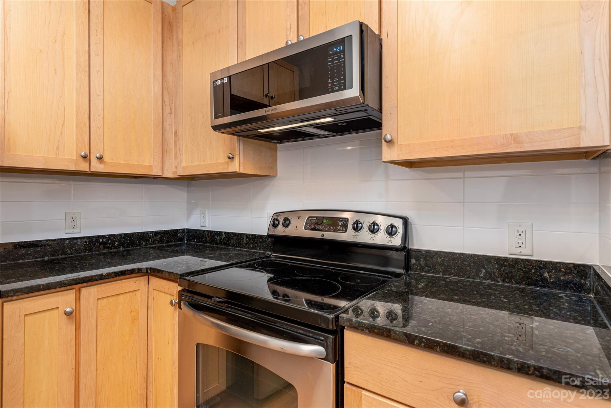 630 Calvert Street, Unit 307 Charlotte, NC 28208 - Photo 7 of 27 a kitchen with a stove and a microwave