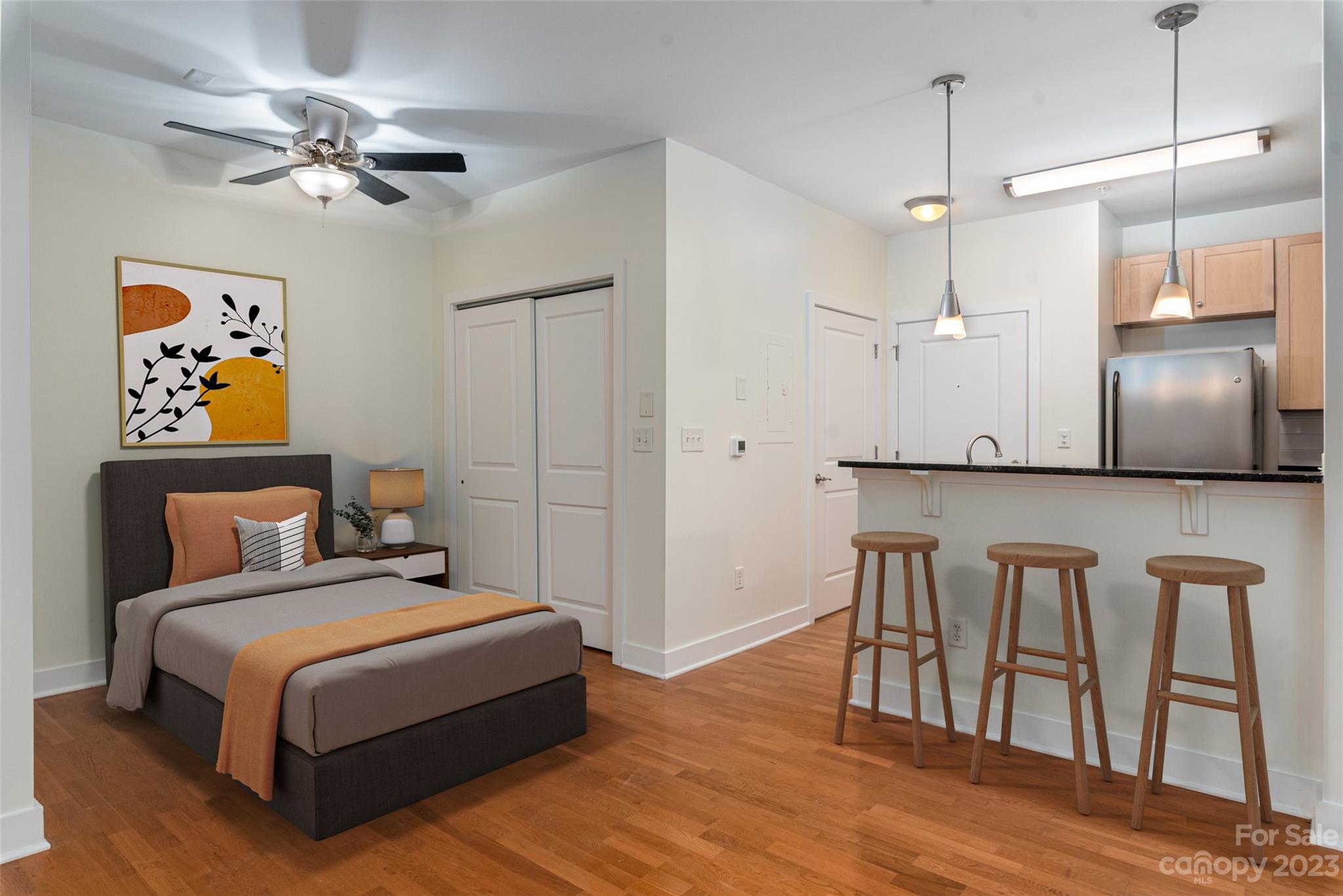 630 Calvert Street, Unit 307 Charlotte, NC 28208 - Photo 9 of 27 a bedroom with a bed and a table with wooden floor