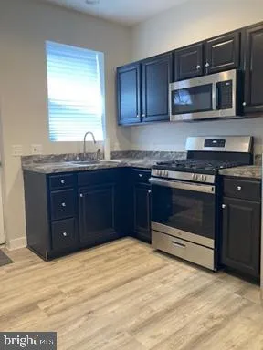a kitchen with stainless steel appliances granite countertop a stove and a microwave