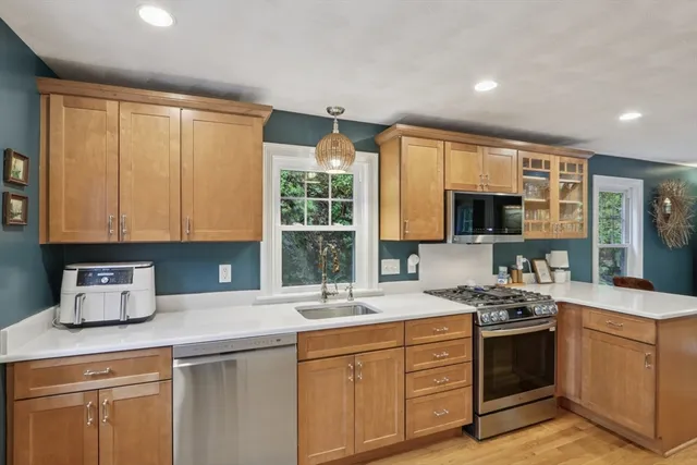 a kitchen with stainless steel appliances granite countertop a sink stove and cabinets