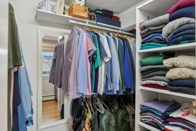 a view of walk in closet with clothes and shoes
