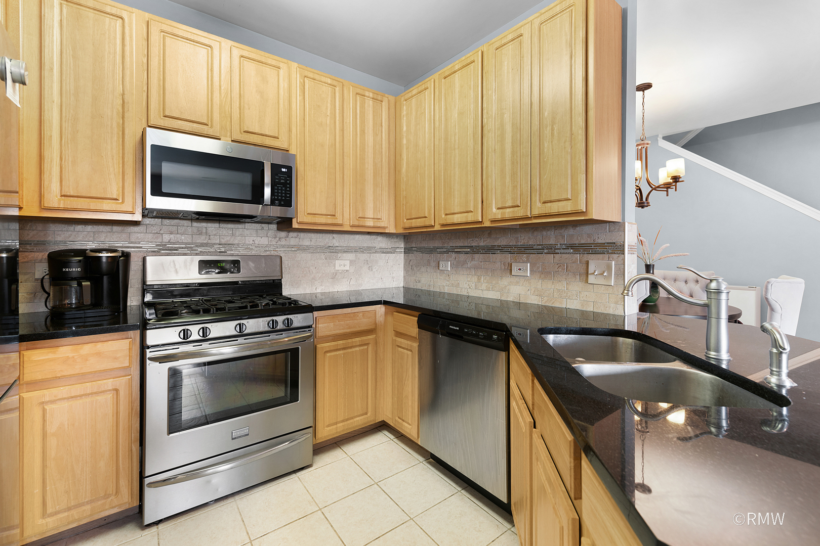 1259 West Lake Street, Unit 304 Addison, IL 60101 - Photo 13 of 43 a kitchen with granite countertop a sink a stove and microwave