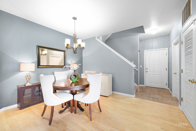 1259 West Lake Street, Unit 304 Addison, IL 60101 - Photo 41 of 43 a dining room with furniture a chandelier and wooden floor