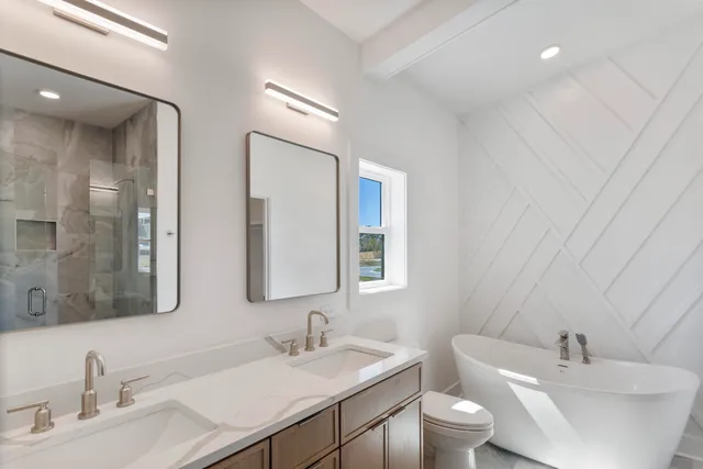 a bathroom with double vanity sinks and a mirror