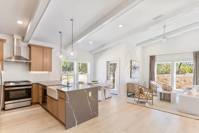 a large kitchen with kitchen island a large window cabinets and stainless steel appliances