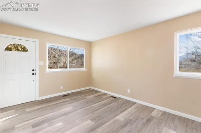 a view of a room with wooden floor and window