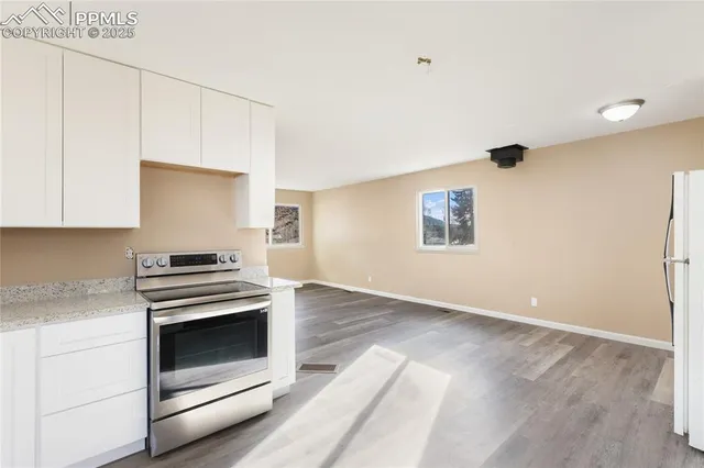 a kitchen with granite countertop white cabinets and white appliances