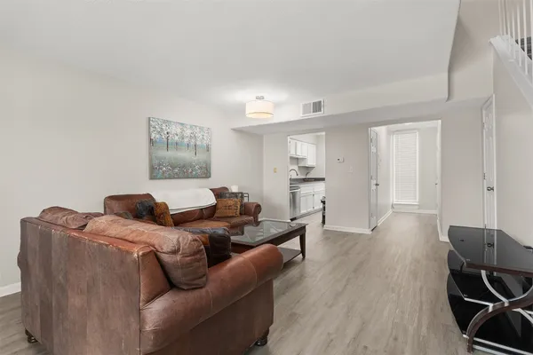a living room with furniture and a wooden floor