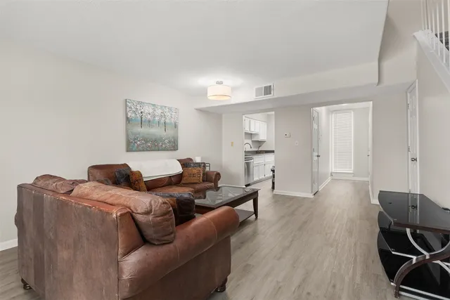 a living room with furniture and a wooden floor