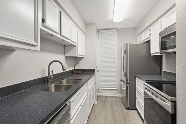 a kitchen with stainless steel appliances granite countertop a sink stove and refrigerator