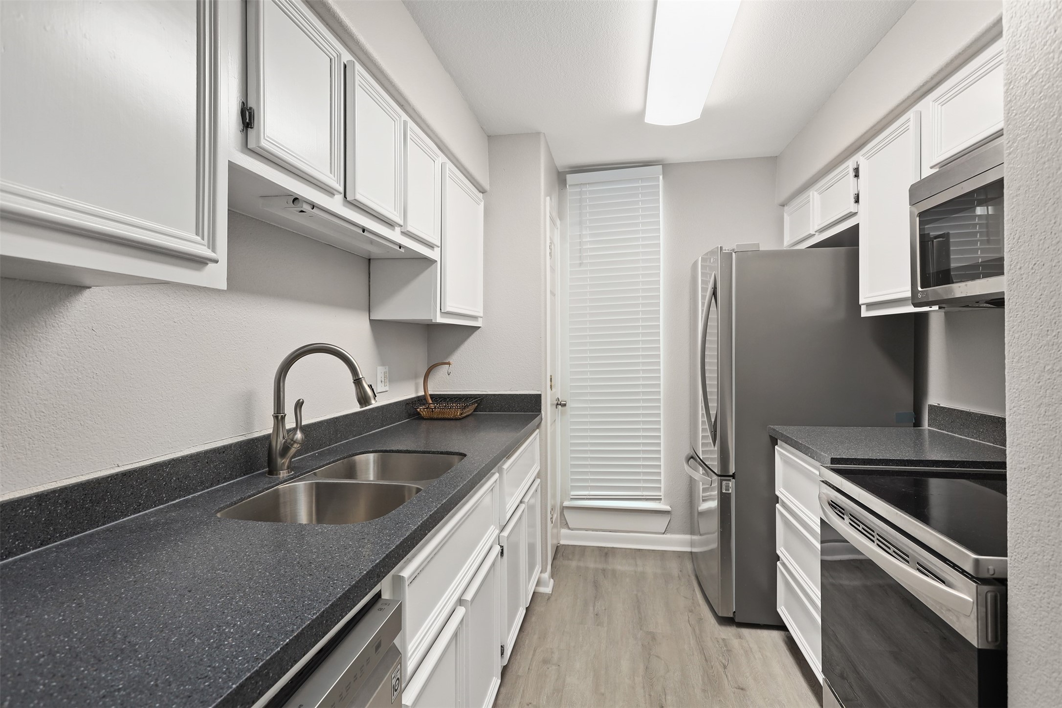 215 Postoffice Street, Unit 1208 Galveston, TX 77550 - Photo 5 of 19 a kitchen with stainless steel appliances granite countertop a sink stove and refrigerator