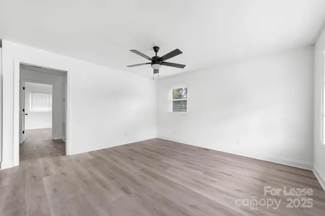 a view of kitchen with stainless steel appliances granite countertop a refrigerator a sink dishwasher and a oven with white cabinets