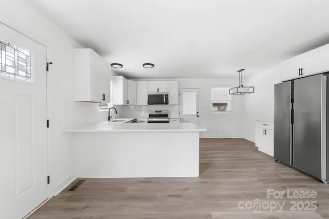 a kitchen with sink cabinets and wooden floor