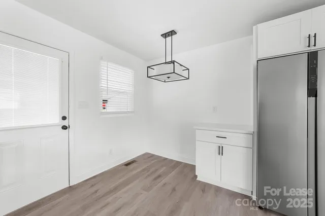 an empty room with wooden floor ceiling fan and windows